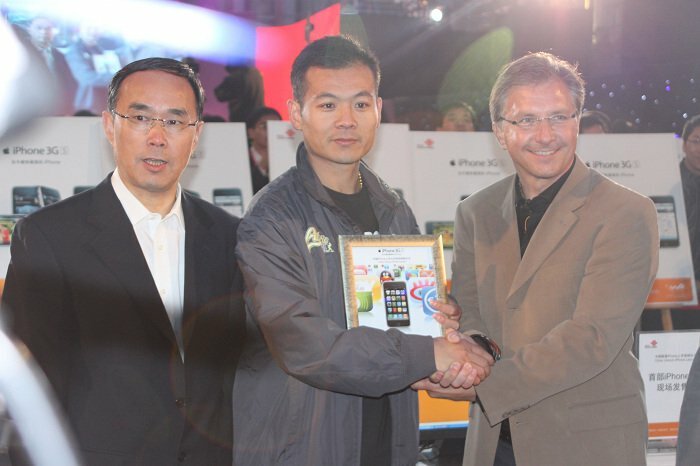 China Unicom Chairman Chang Xiaobing (left) along with first iPhone buyer (center) receiving congratulations from Apple VP Greg Joswiak